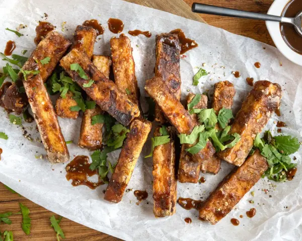 Marinierter Tofu, knusprig gebraten und mit frischem Koriander und einer dunklen Sauce garniert. Perfekt zum **Tofu marinieren** und Genießen.