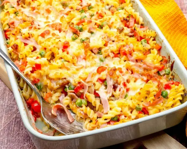 Ein köstlicher, schneller Auflauf ohne Vorkochen mit Nudeln, Schinken, Erbsen und Paprika, überbacken mit Käse.