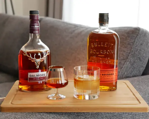 Zwei Flaschen und Gläser mit Whiskey zeigen die whiskey sorten unterschiede: ein Dalmore Scotch und ein Bulleit Bourbon.
