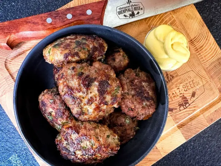 Leckeres Buletten Rezept: Saftige Frikadellen in einer Schüssel, daneben Senf und ein Messer. Perfekt für den Grill oder die Pfanne.