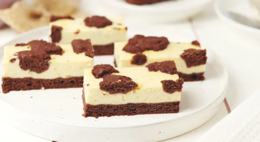 Saftiger russischer Zupfkuchen vom Blech, in Stücke geschnitten, mit Schokoladenstückchen auf cremiger Käsemasse.