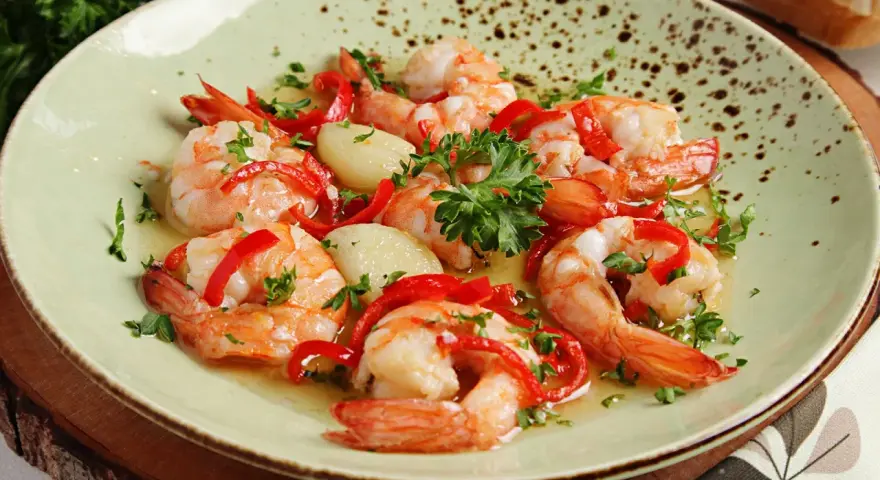 Garnelen in Knoblauchöl mit Paprika und Petersilie, ein köstliches Gericht, das perfekt zu einem Glas Wein passt.