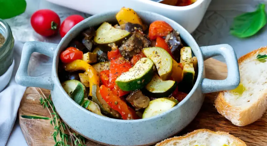Herzhaftes Ratatouille mit Zucchini, Aubergine und Paprika, serviert in einer Schüssel mit Brot. Perfekt für Ratatouille Rezepte.