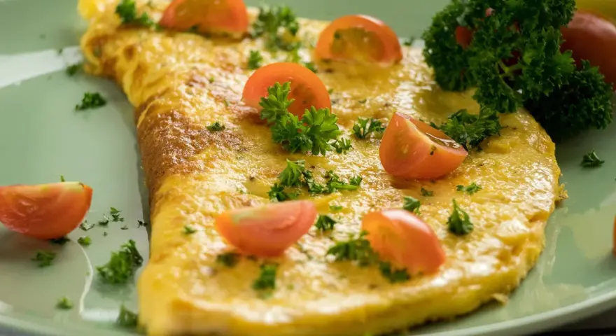 Ein goldgelbes Omelett, garniert mit Kirschtomaten und Petersilie. Ein einfaches und leckeres Omelett Rezept für jeden Tag.