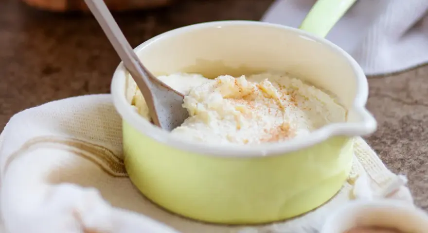 Cremiger Grießbrei, perfekt für ein schnelles Grießbrei Rezept, bestreut mit Zimt in einer kleinen gelben Schüssel.