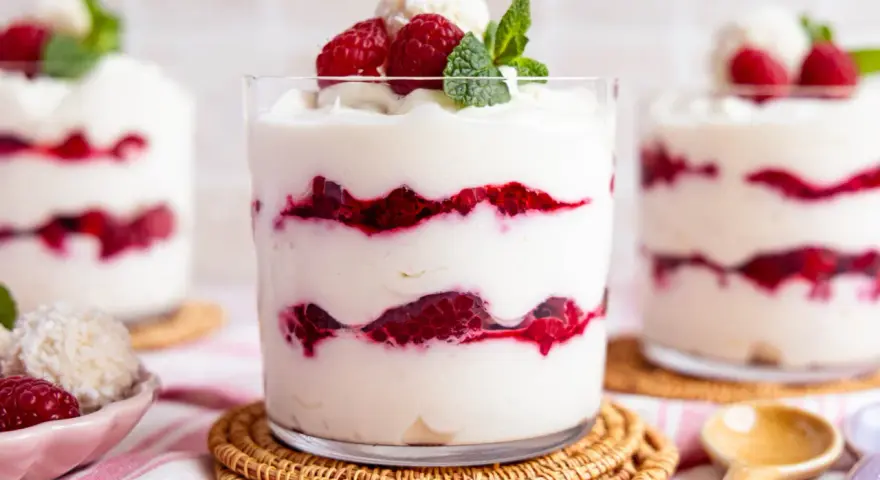 Schichtdessert mit Himbeeren und Kokosflocken, das an Raffaello Creme erinnert.