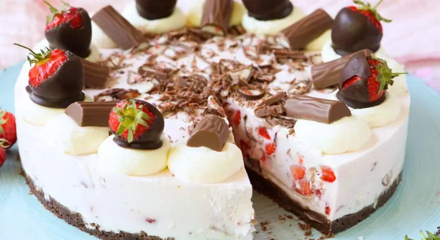 Eine köstliche Yogurette Torte mit frischen Erdbeeren, Schokostückchen und Sahnetupfern. Ein Genuss für alle Sinne!