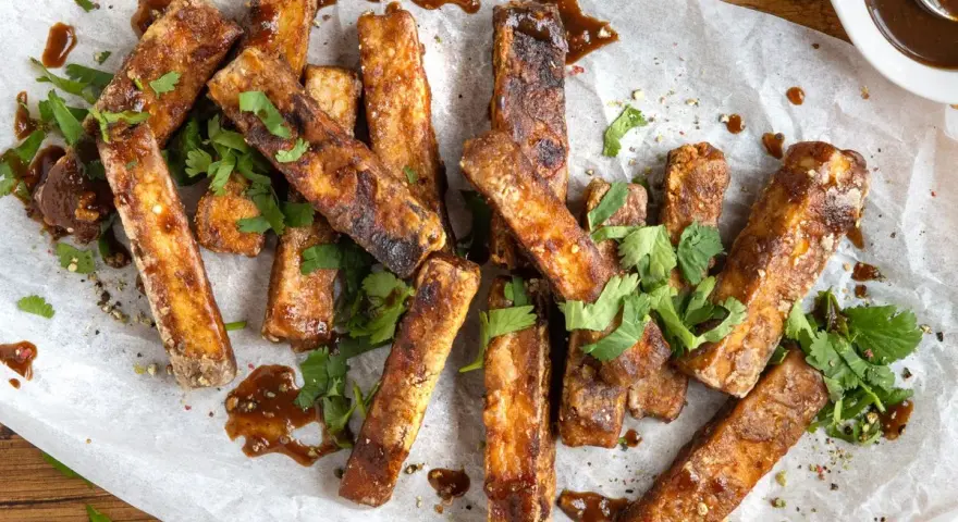 Marinierter Tofu, knusprig gebraten und mit frischem Koriander und einer dunklen Sauce garniert. Perfekt zum **Tofu marinieren** und Genießen.