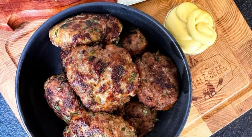 Leckeres Buletten Rezept: Saftige Frikadellen in einer Schüssel, daneben Senf und ein Messer. Perfekt für den Grill oder die Pfanne.