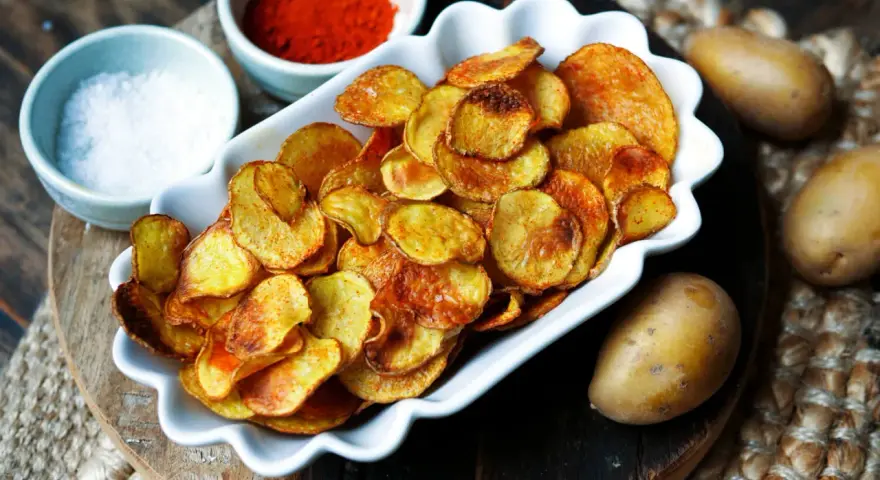 Selbstgemachte Kartoffelchips, goldbraun und knusprig, mit Salz und Paprikapulver. So einfach ist kartoffelchips selber machen!