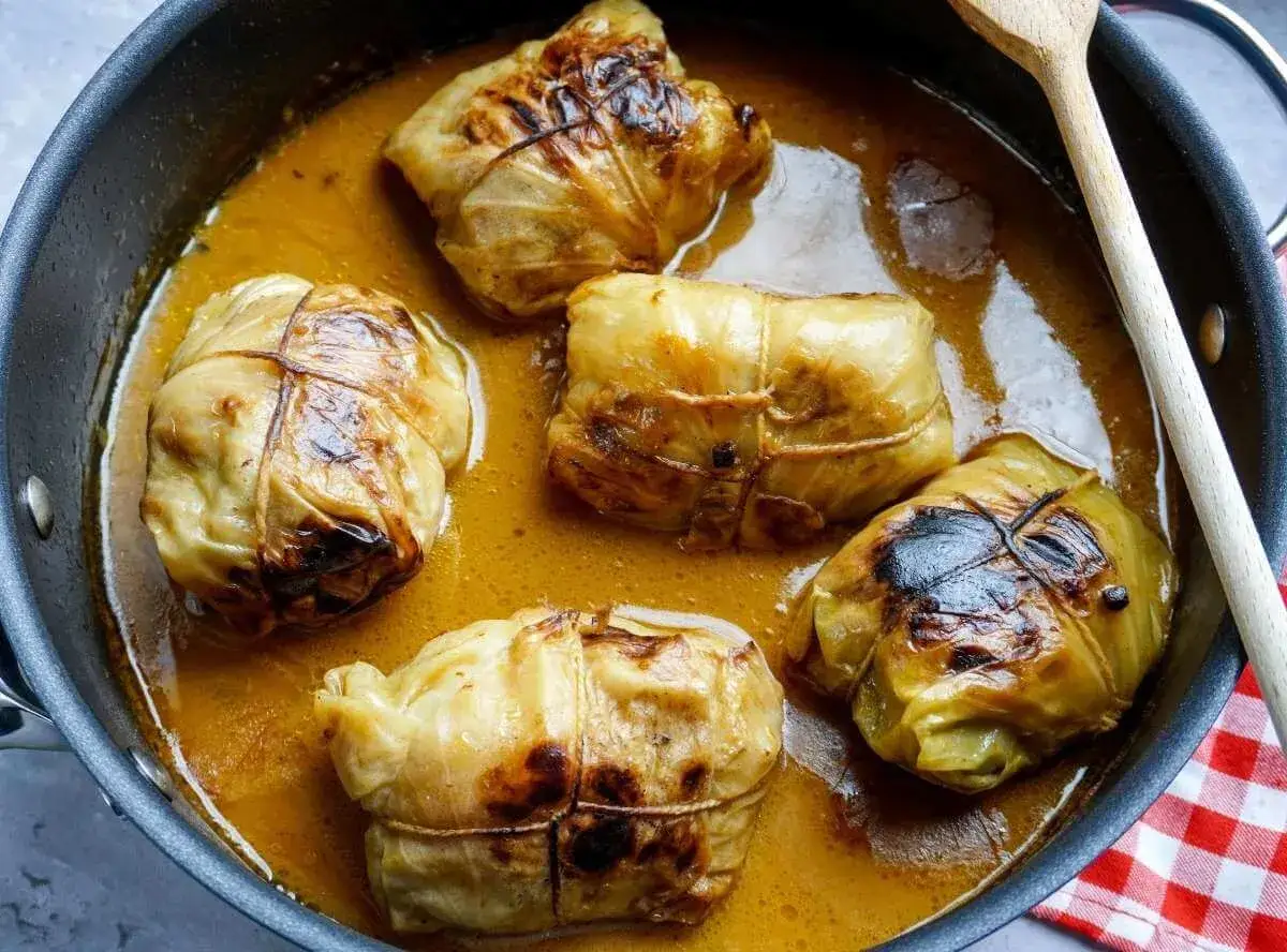 Fünf Kohlrouladen im Topf, bereit für ein köstliches Kohlrouladen Rezept.