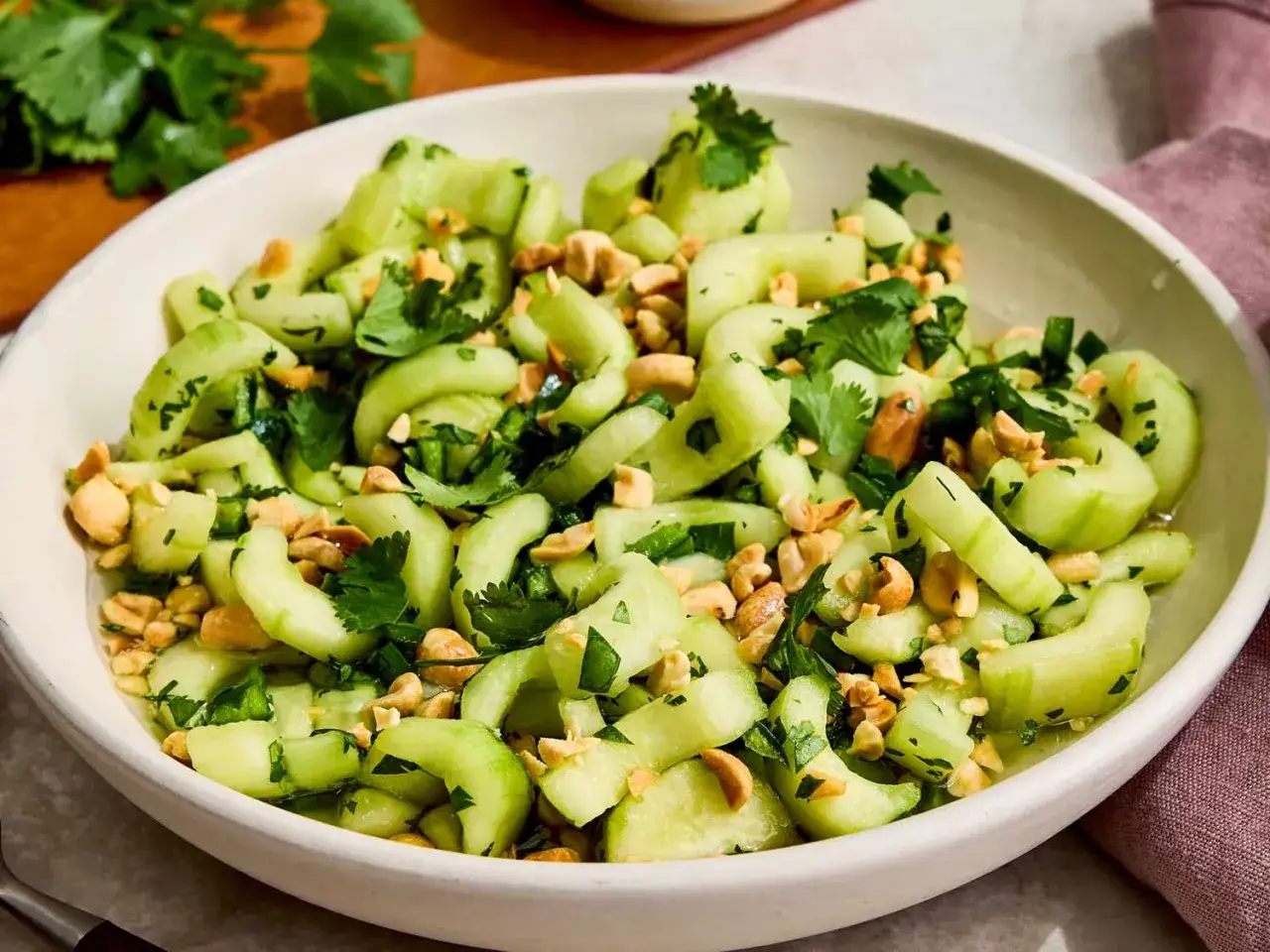 Erfrischender Gurkensalat mit Koriander und Erdnüssen. Ein leichtes Gericht, das perfekt zu vielen Rezepten mit Gurken passt.