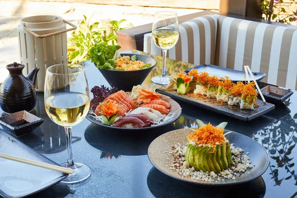 Ein Glas Weißwein passt hervorragend zu diesem Sushi- und Sashimi-Teller.