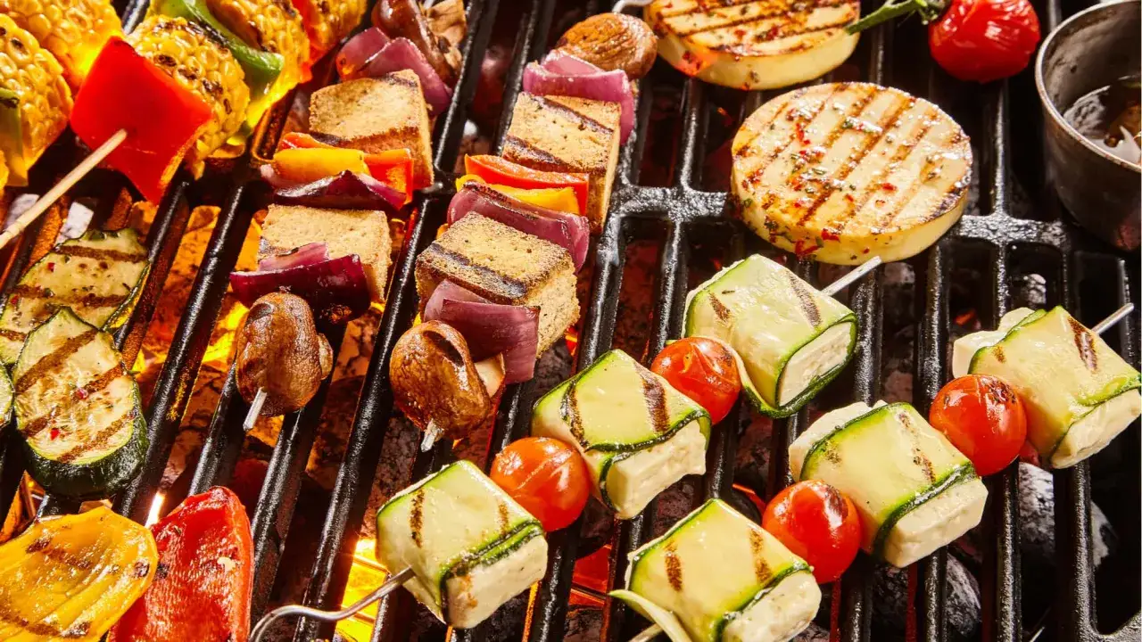 Bunte Spieße mit Tofu, Zucchini, Tomaten, Mais und Paprika brutzeln auf dem Grill. Ein Fest für das vegetarisch grillen!