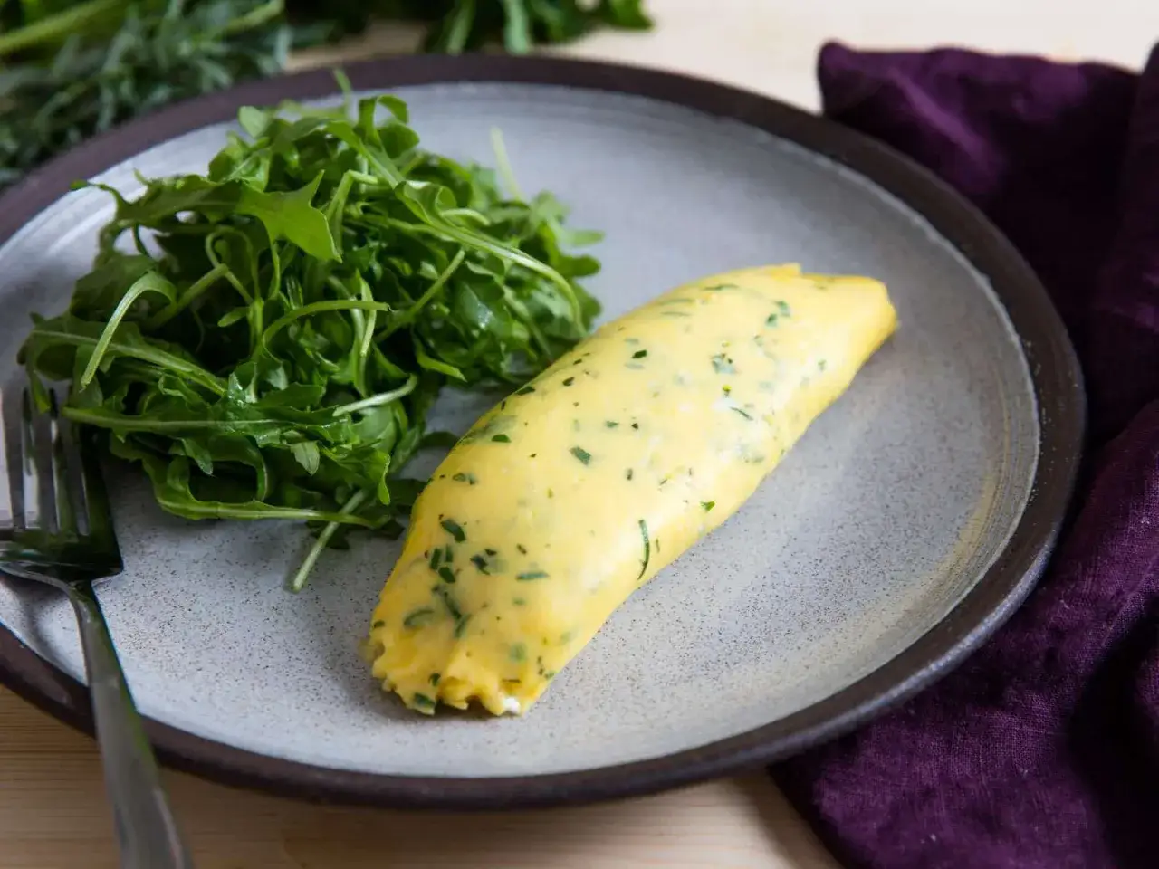 Ein perfekt gerolltes Omelett mit Kräutern, serviert mit Rucola. Ein einfaches und leckeres Omelett Rezept für jeden Tag.