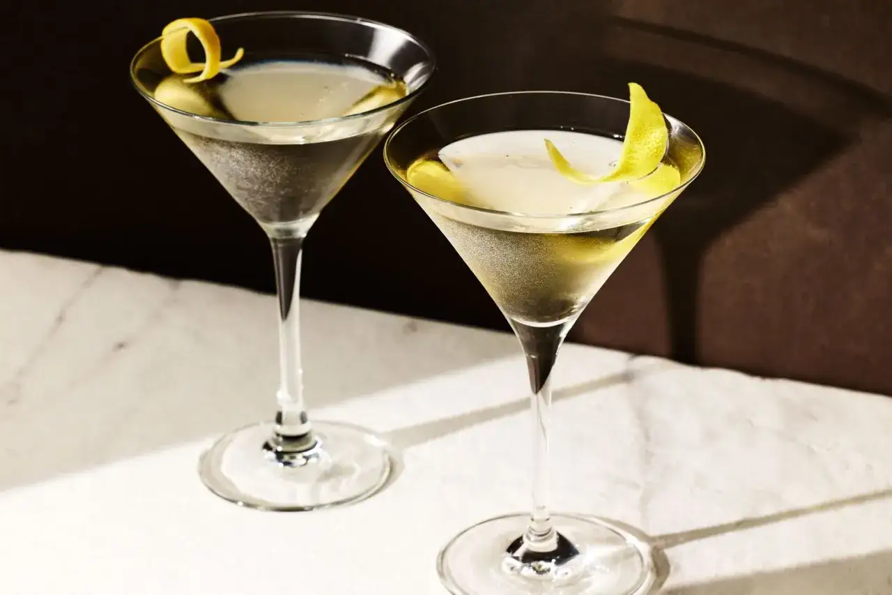 Zwei elegante Gläser mit einem martini trocken, garniert mit Zitronenzesten. Perfekt für einen stilvollen Abend.
