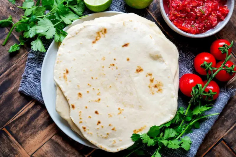 Frische Tortillas, perfekt zum wraps selber machen. Dazu Salsa, Kirschtomaten, Limetten und Koriander.