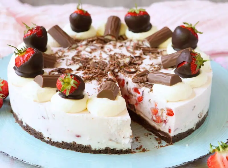 Eine köstliche Yogurette Torte mit frischen Erdbeeren, Schokostückchen und Sahnetupfern. Ein Genuss für alle Sinne!
